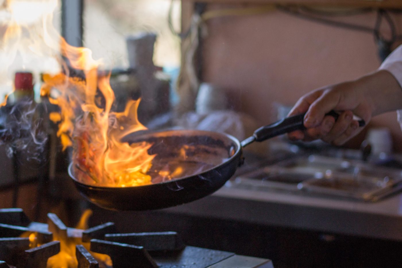 Chef flambéing a pan in the restaurant kitchen